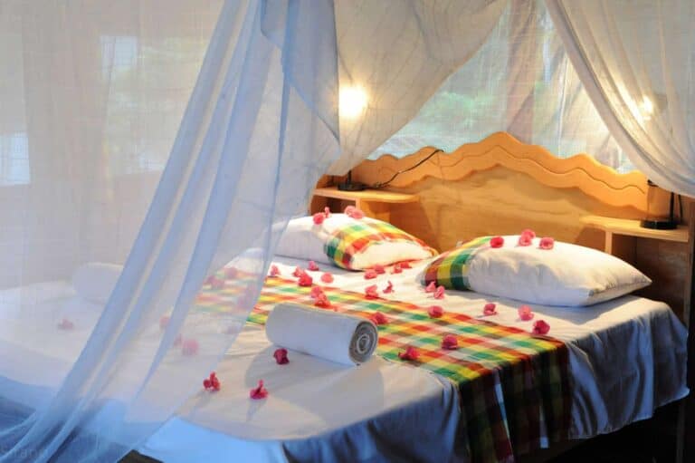 Tweepersoonsbed met klamboe in een cabin van Danpaati River Lodge