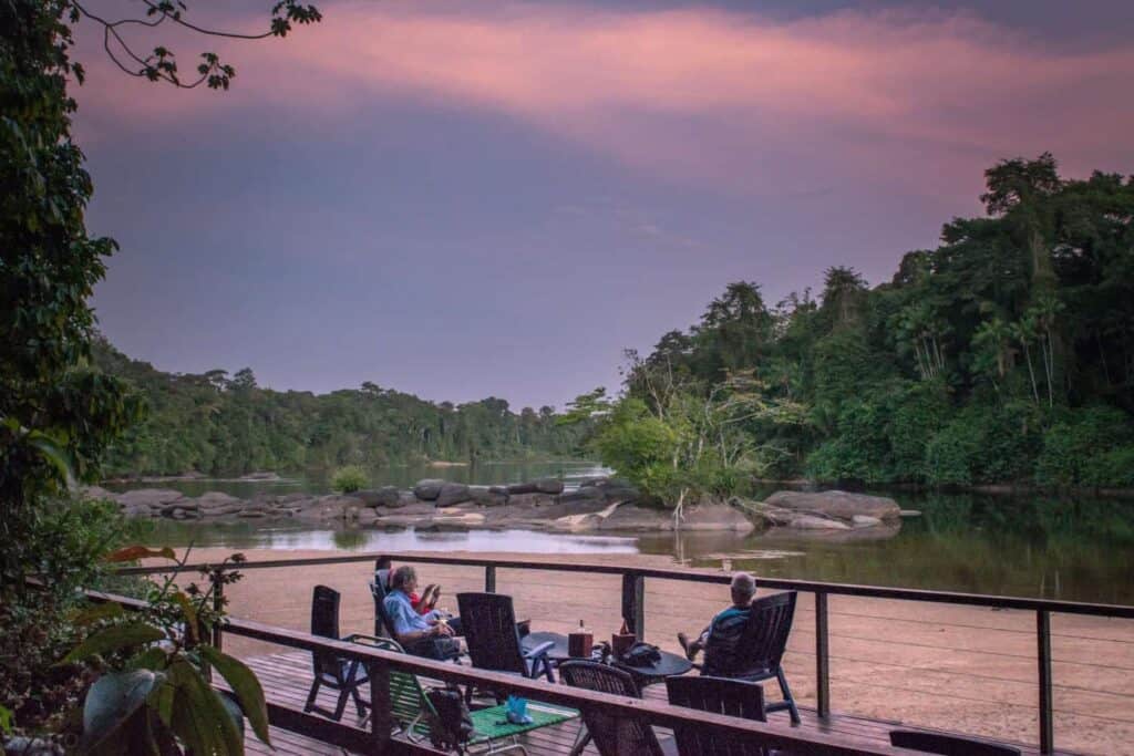 Gasten op het rivierterras van Danpaati tijdens een roze zonsondergang
