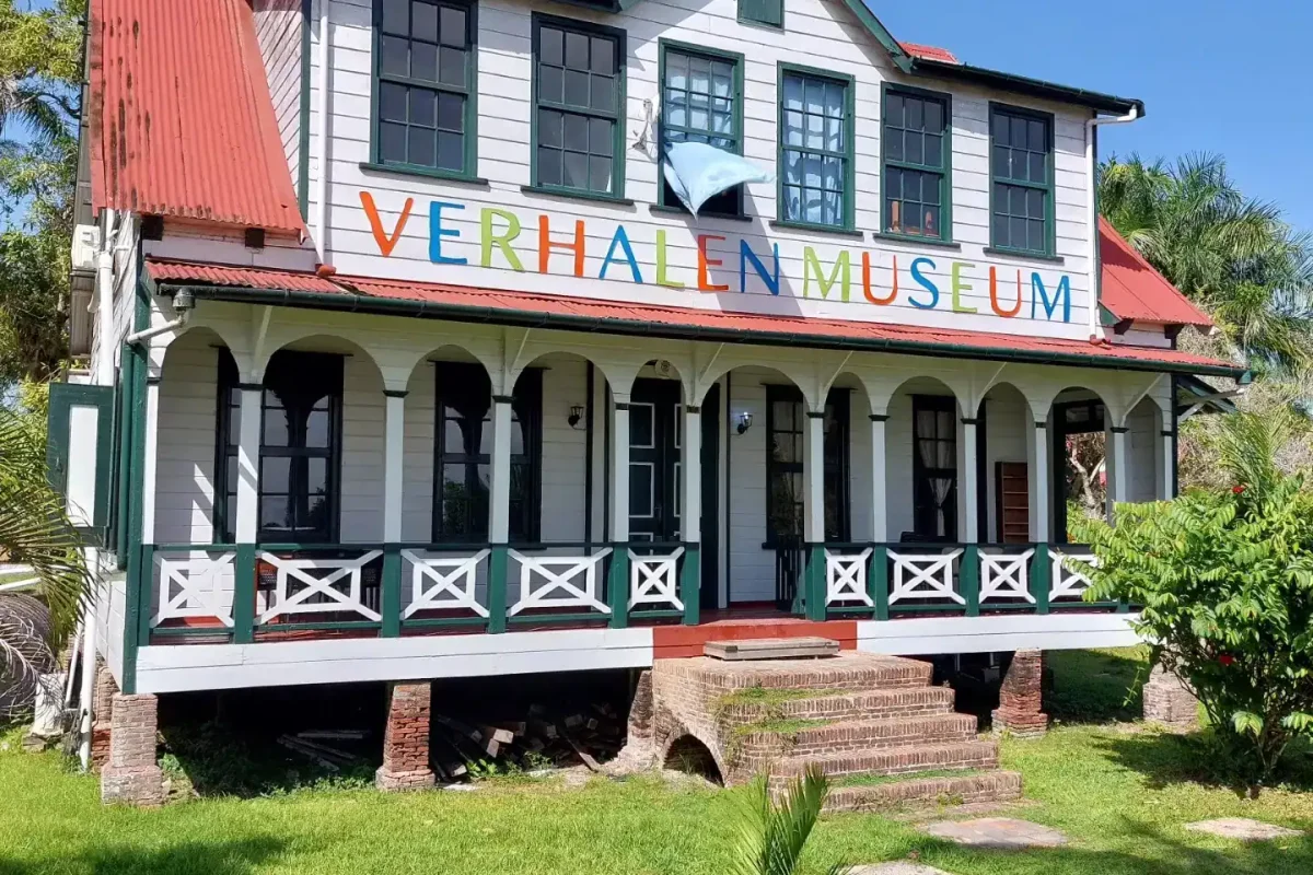 Het Verhalenmuseum in een wit houten plantagegebouw met rood dak en veranda