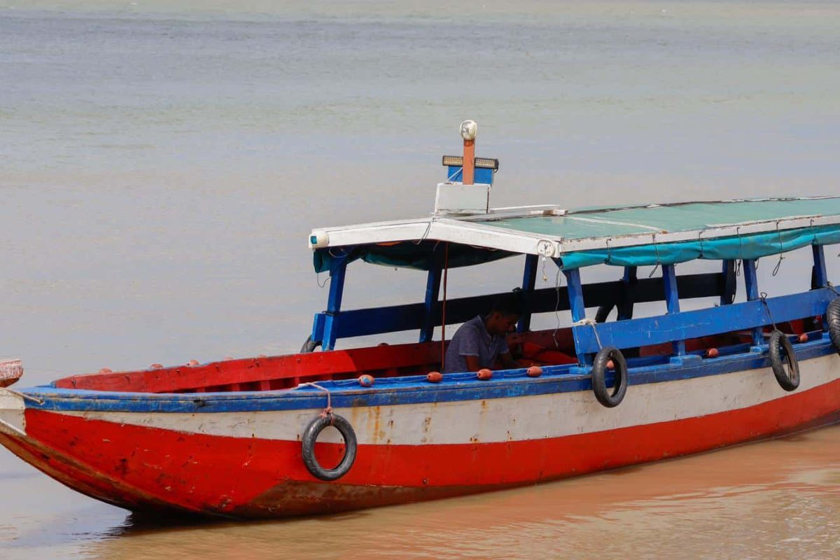 Traditionele overdekte houten boot met blauw dak vaart over de rivier